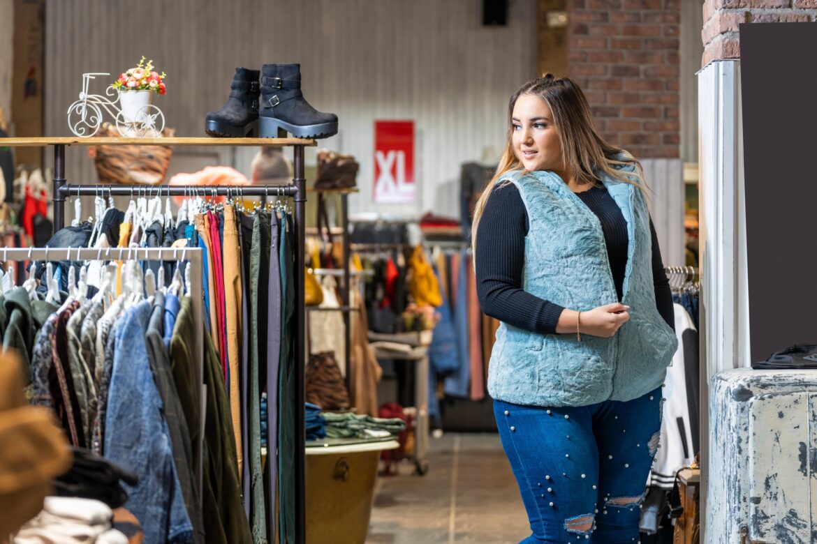 Beautiful overweight woman trying on clothes in a clothing store in the plus size section