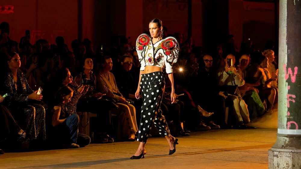 A young female model walking on the ramp in a fashion show