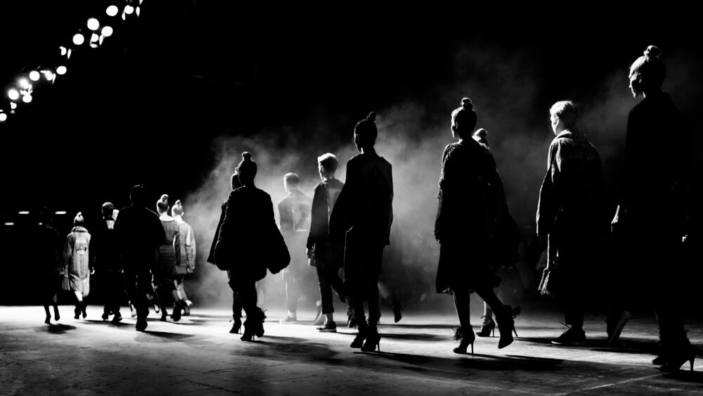 B&W picture of models walking on the ramp in a fashion show